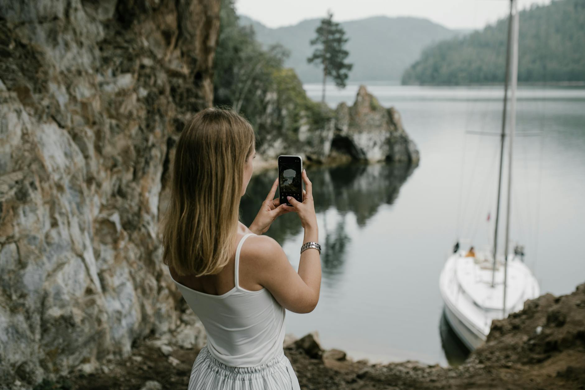 woman taking a picture of the lake